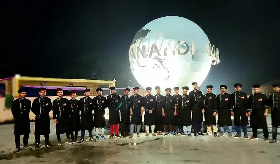 The full brigade in uniform outside the venue entrance at night.