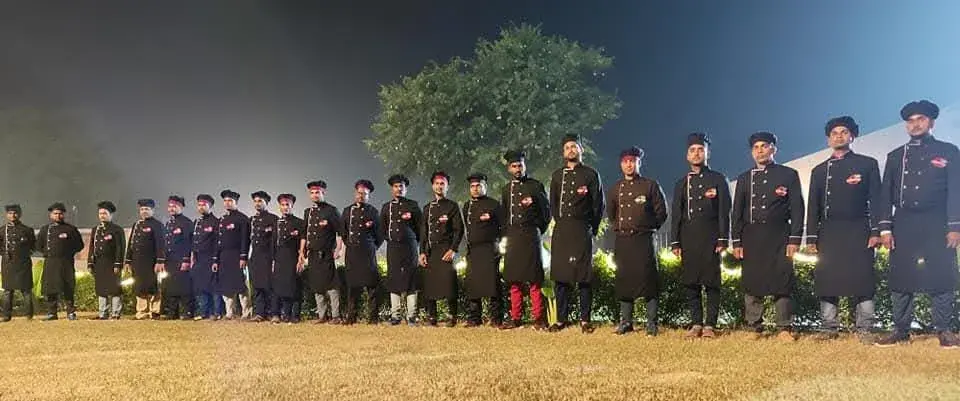 The brigade lined up along the edge of the event lawn under floodlight.