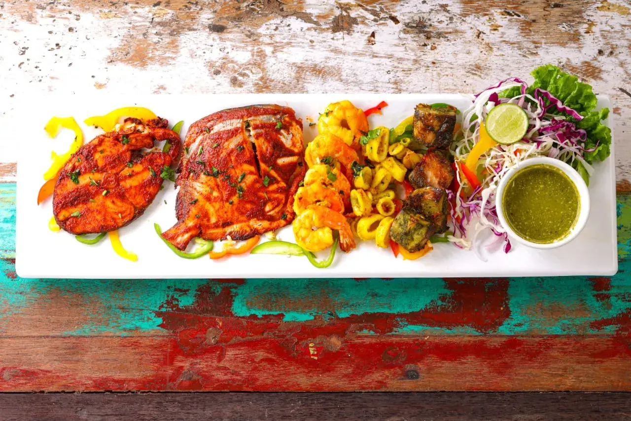 A tandoori platter plated with accompaniments.
