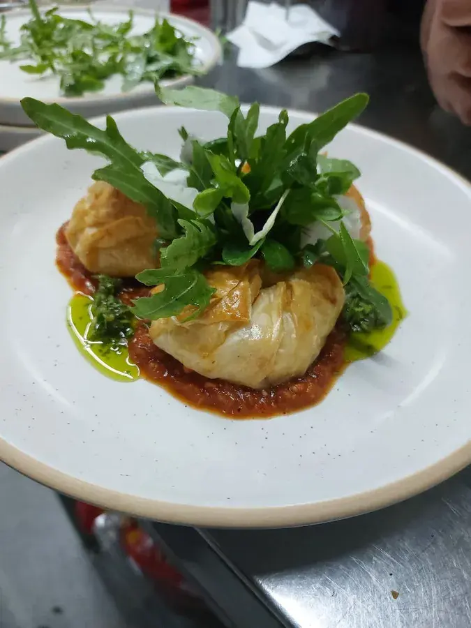 A plated main course finished with a rocket garnish.