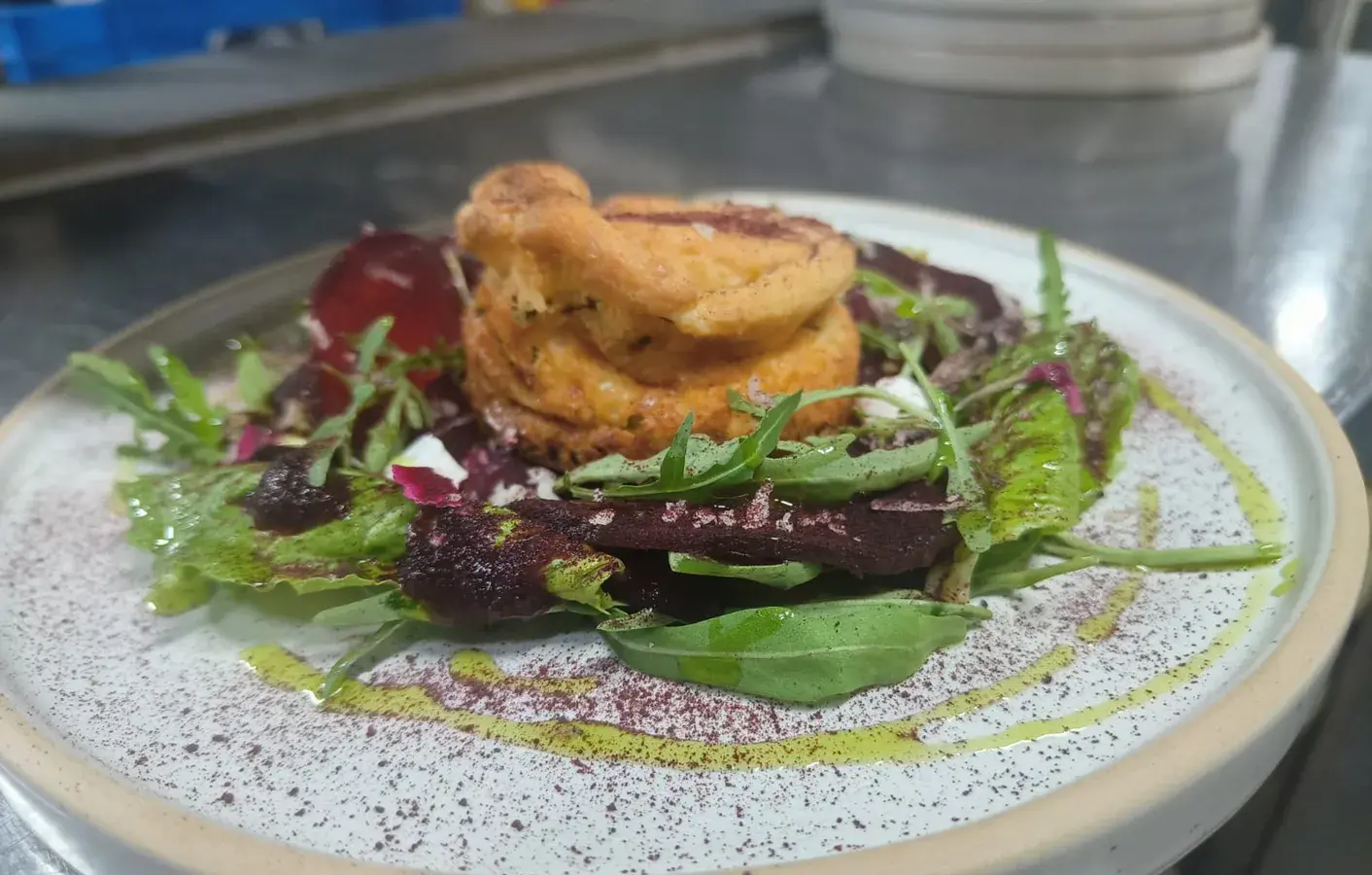 A plated starter on a bed of dressed leaves.
