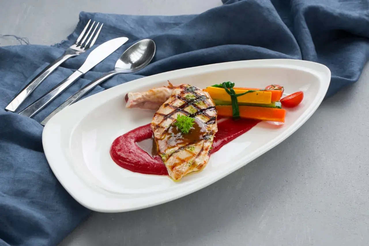 A grilled fish plate with vegetables.