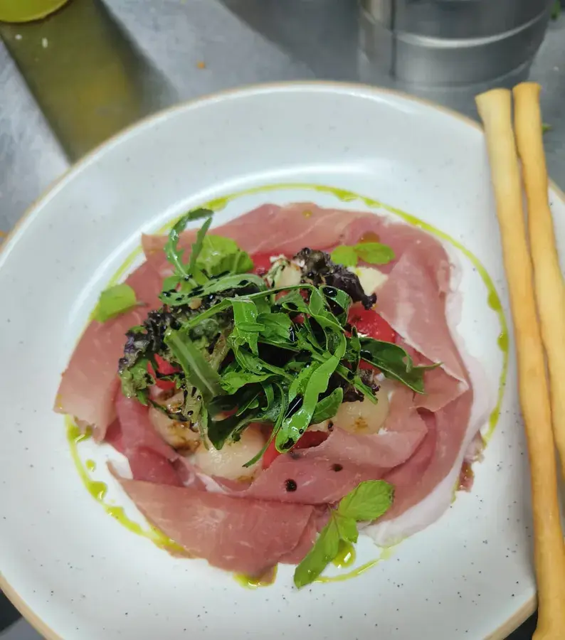 A carpaccio plated with rocket and oil.