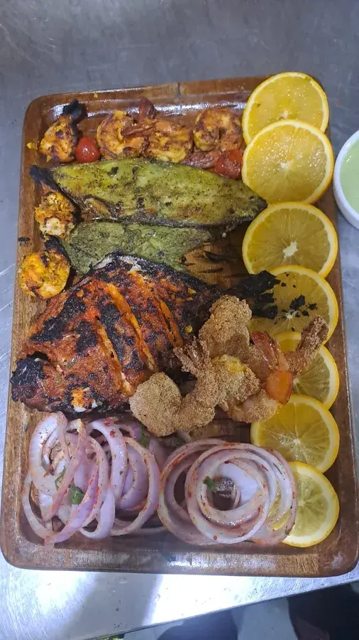 A mixed grill platter with lemon and onion.