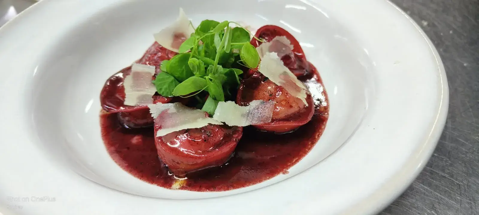 A plated tomato dish with cheese and herbs.