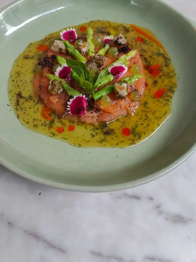 A cured salmon plate finished with flowers.