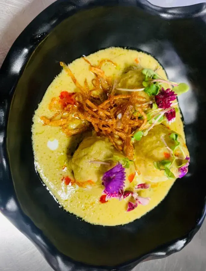 A plated dish topped with a crisp garnish.