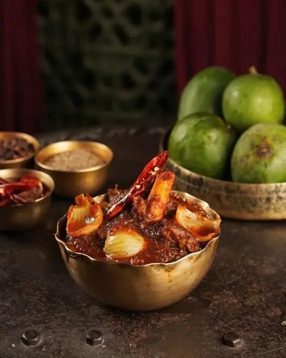 A seafood dish served in brass with fresh produce.