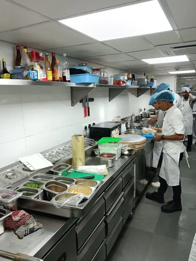 A chef working the pass in a commercial kitchen.