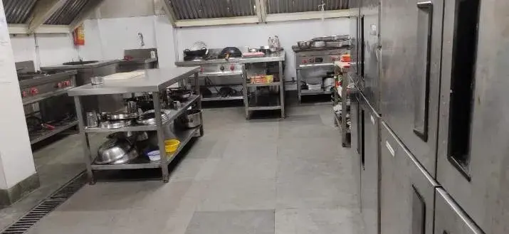 A commercial kitchen line with cooking suite and refrigeration.