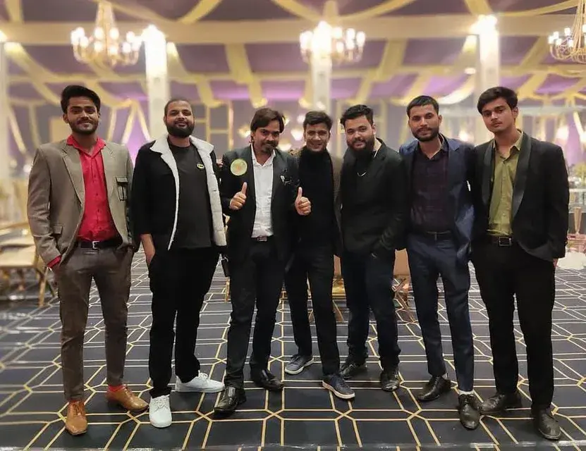 The senior team assembled indoors at the close of an event.