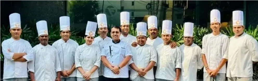 A full chef brigade lined up in whites.