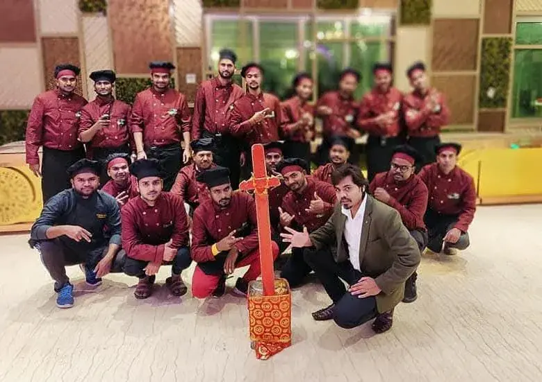 The catering team in maroon service uniform gathered together after an event.