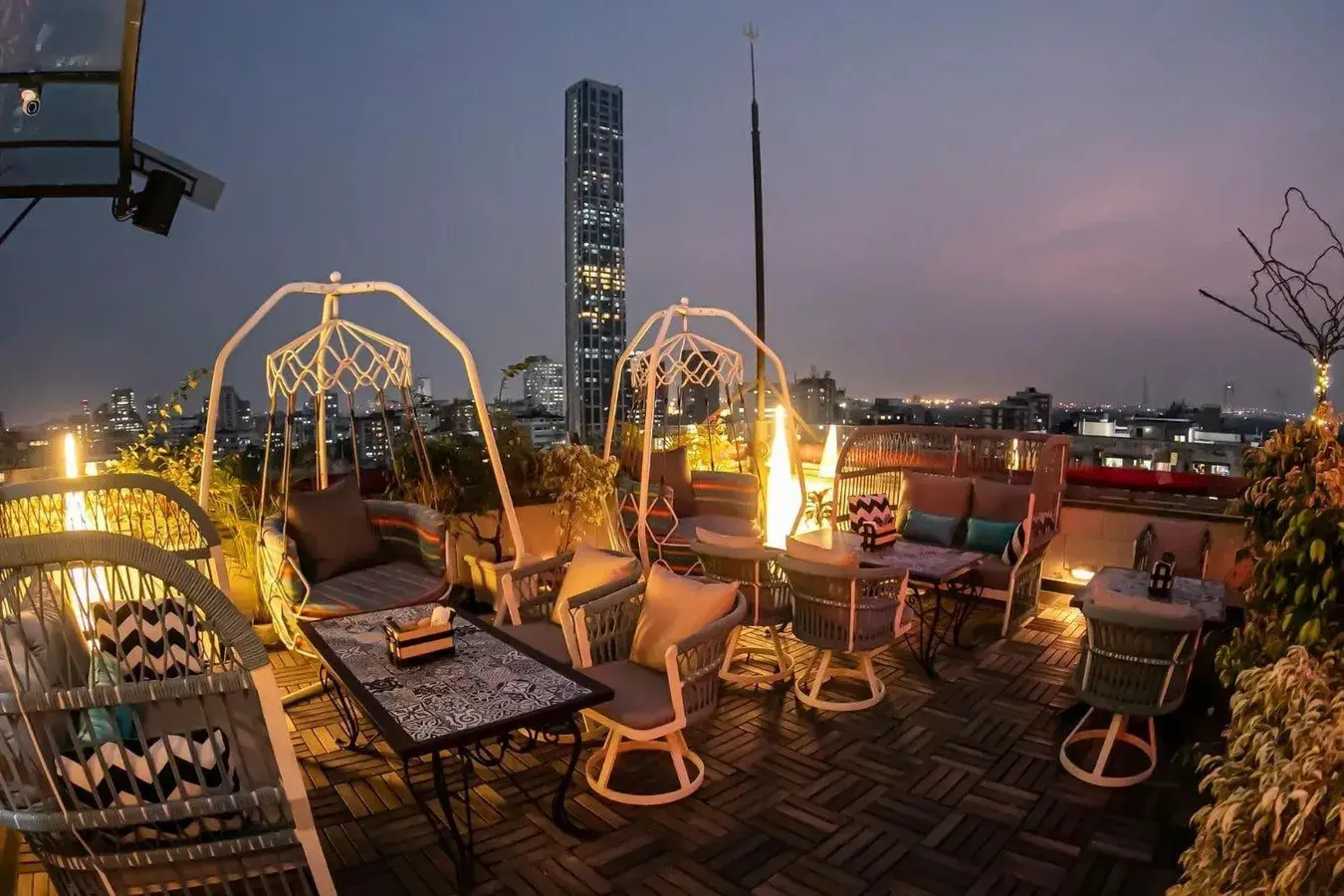 A rooftop dining terrace set for service at dusk.
